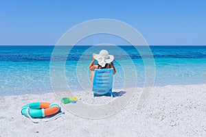 girl with white straw hat relaxes in front of the sea photo